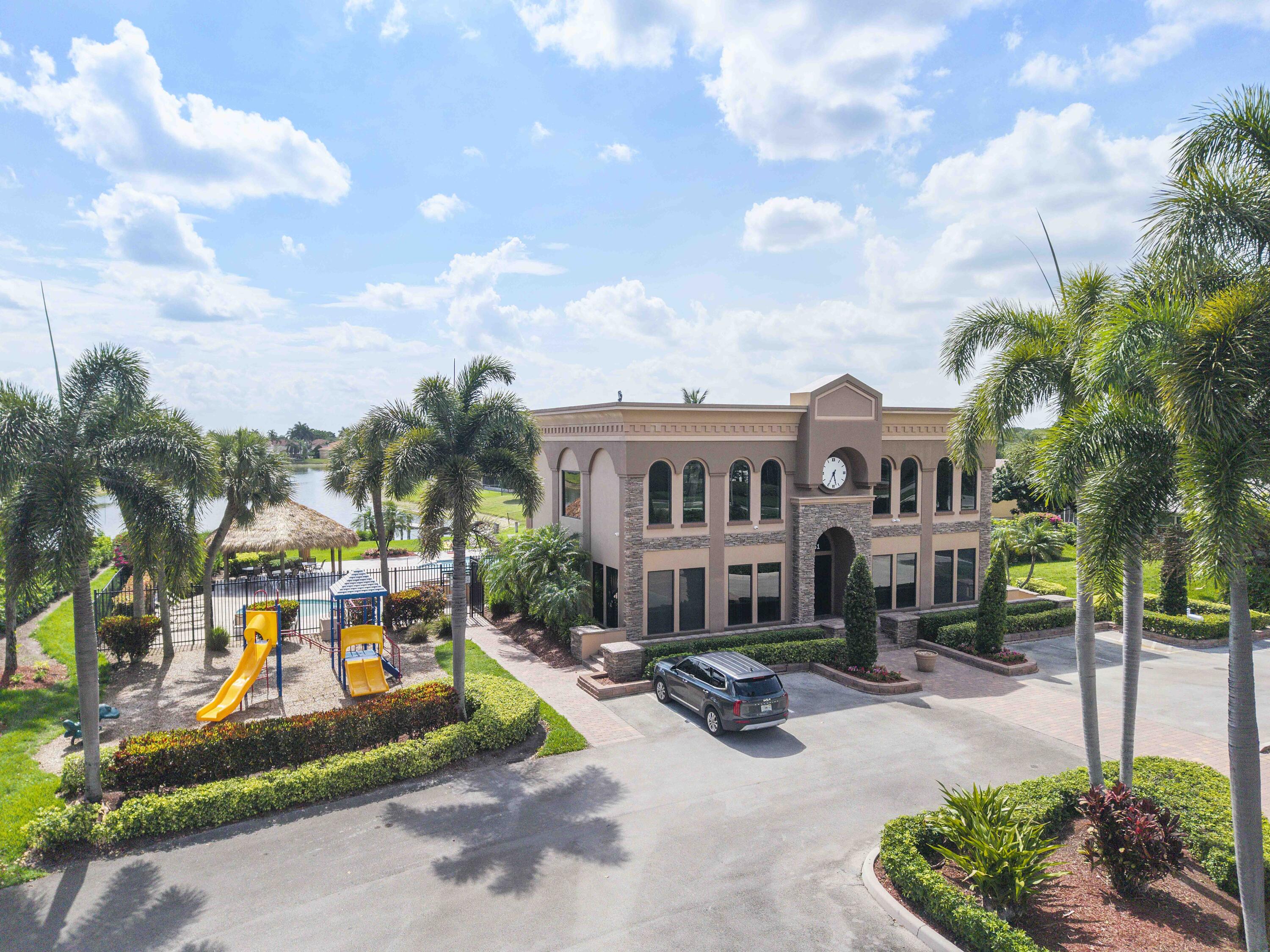 12328 St Simon Drive Boca Raton, FL 33428 - Photo 44 of 52 a view of a white house with a big yard and potted plants