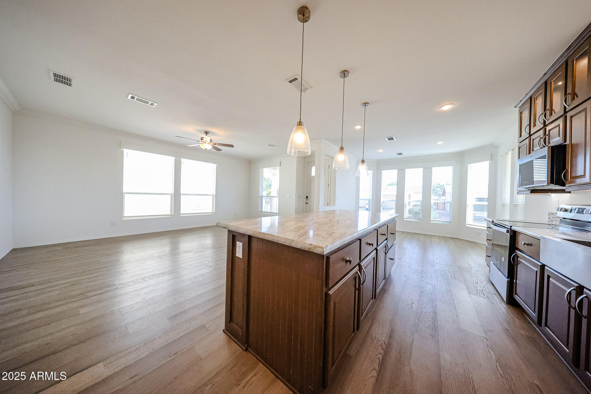 16101 North El Mirage Road, Unit 16 El Mirage, AZ 85335 - Photo 11 of 25 a kitchen with kitchen island wooden floors and stainless steel appliances