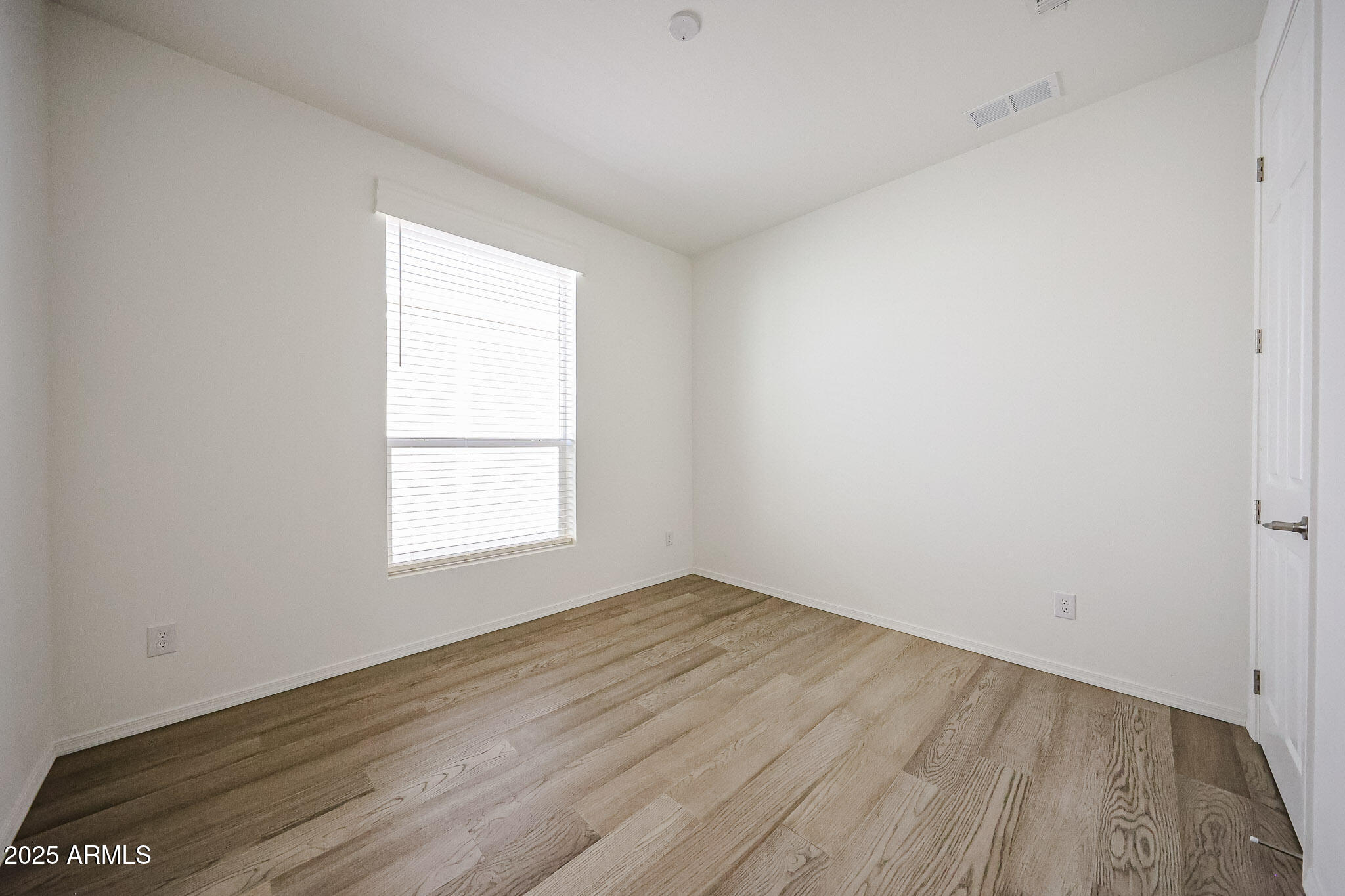 16101 North El Mirage Road, Unit 16 El Mirage, AZ 85335 - Photo 15 of 25 an empty room with wooden floor and windows
