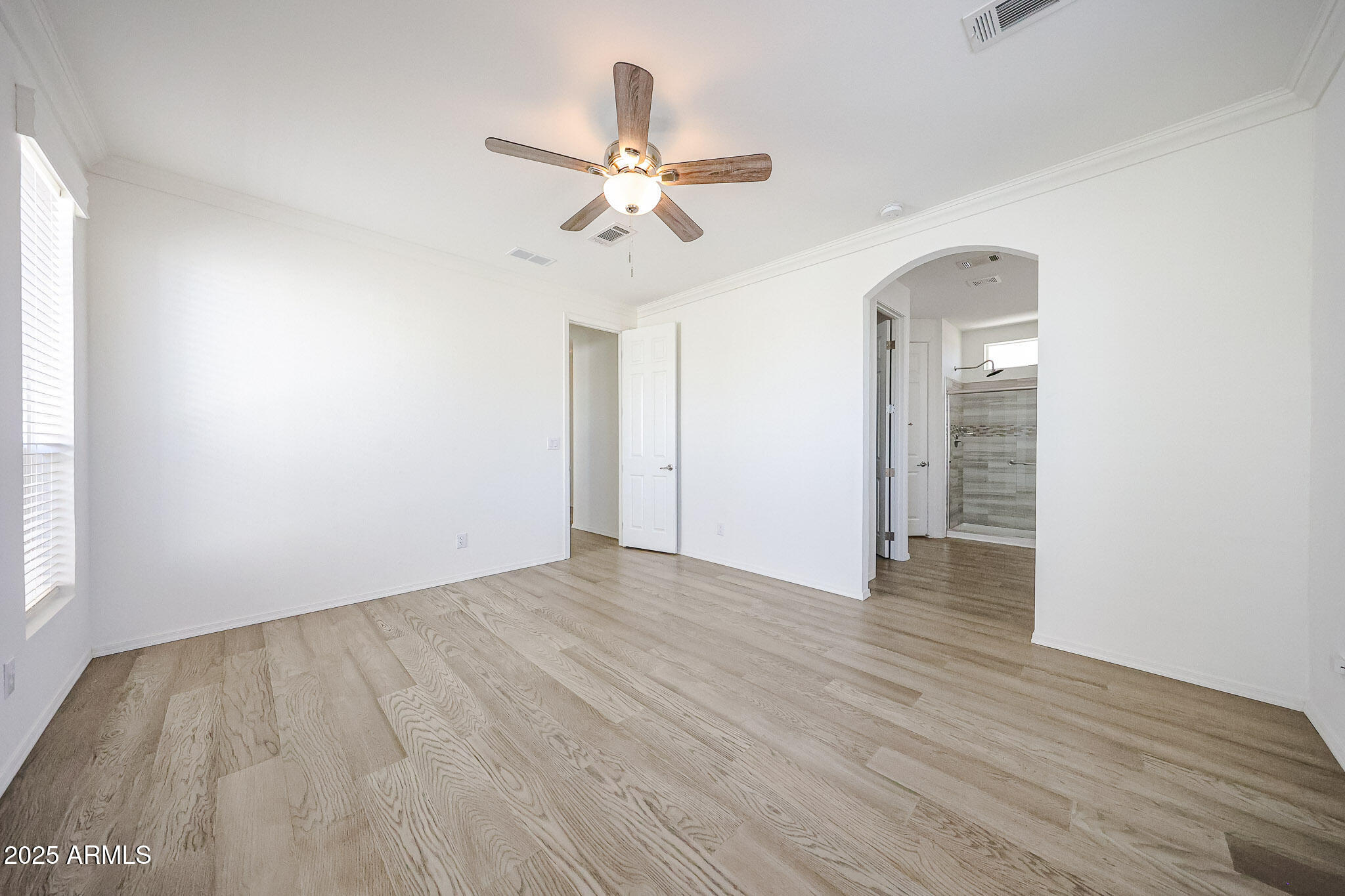 16101 North El Mirage Road, Unit 16 El Mirage, AZ 85335 - Photo 19 of 25 an empty room with wooden floor fan and windows