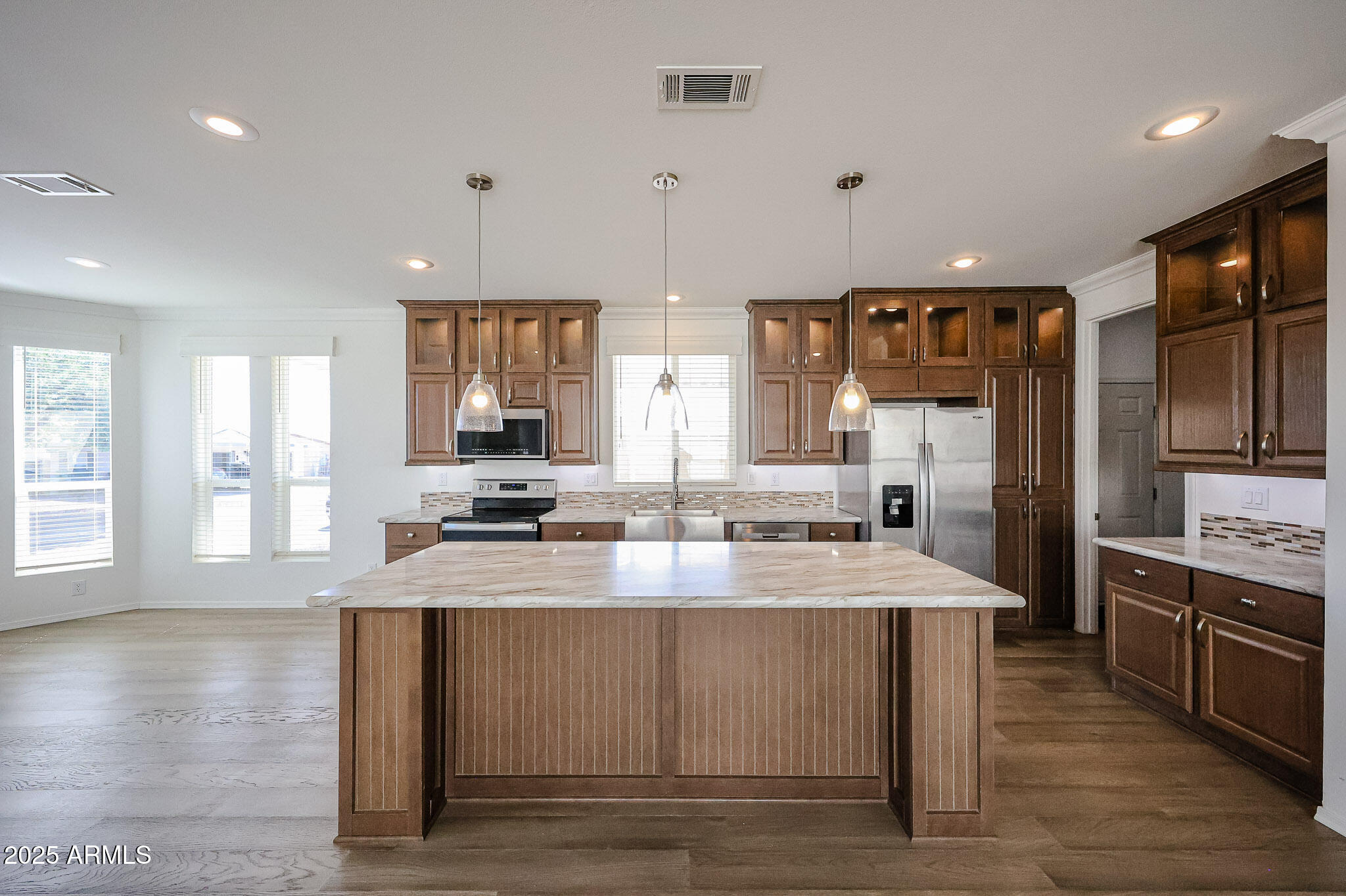 16101 North El Mirage Road, Unit 16 El Mirage, AZ 85335 - Photo 3 of 25 a large kitchen with kitchen island a sink dishwasher a stove and a refrigerator with wooden floor