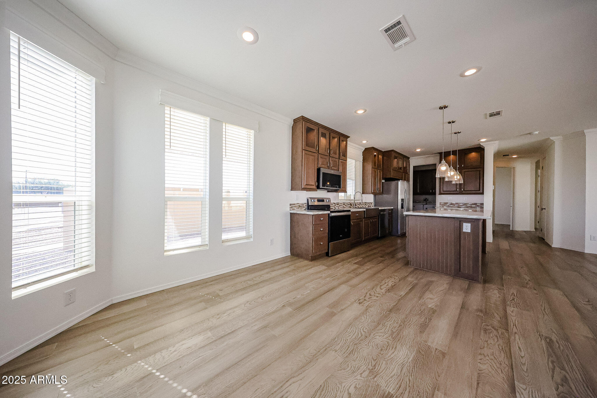 16101 North El Mirage Road, Unit 16 El Mirage, AZ 85335 - Photo 8 of 25 a kitchen with stainless steel appliances a stove top oven a sink dishwasher a refrigerator and white cabinets with wooden floor