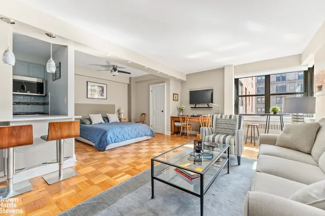 a living room with furniture kitchen view and a flat screen tv