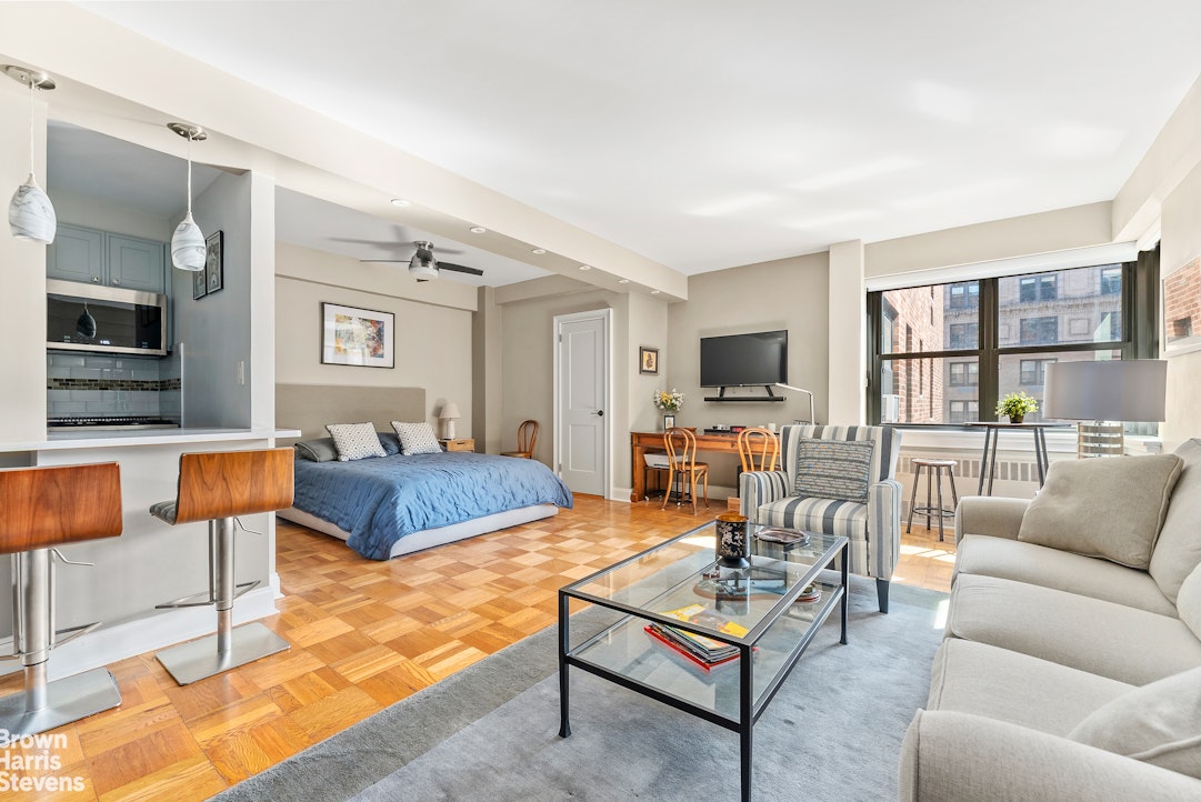 11 Riverside Drive, Unit 13GE Manhattan, NY 10023 - Photo 1 of 12 a living room with furniture kitchen view and a flat screen tv