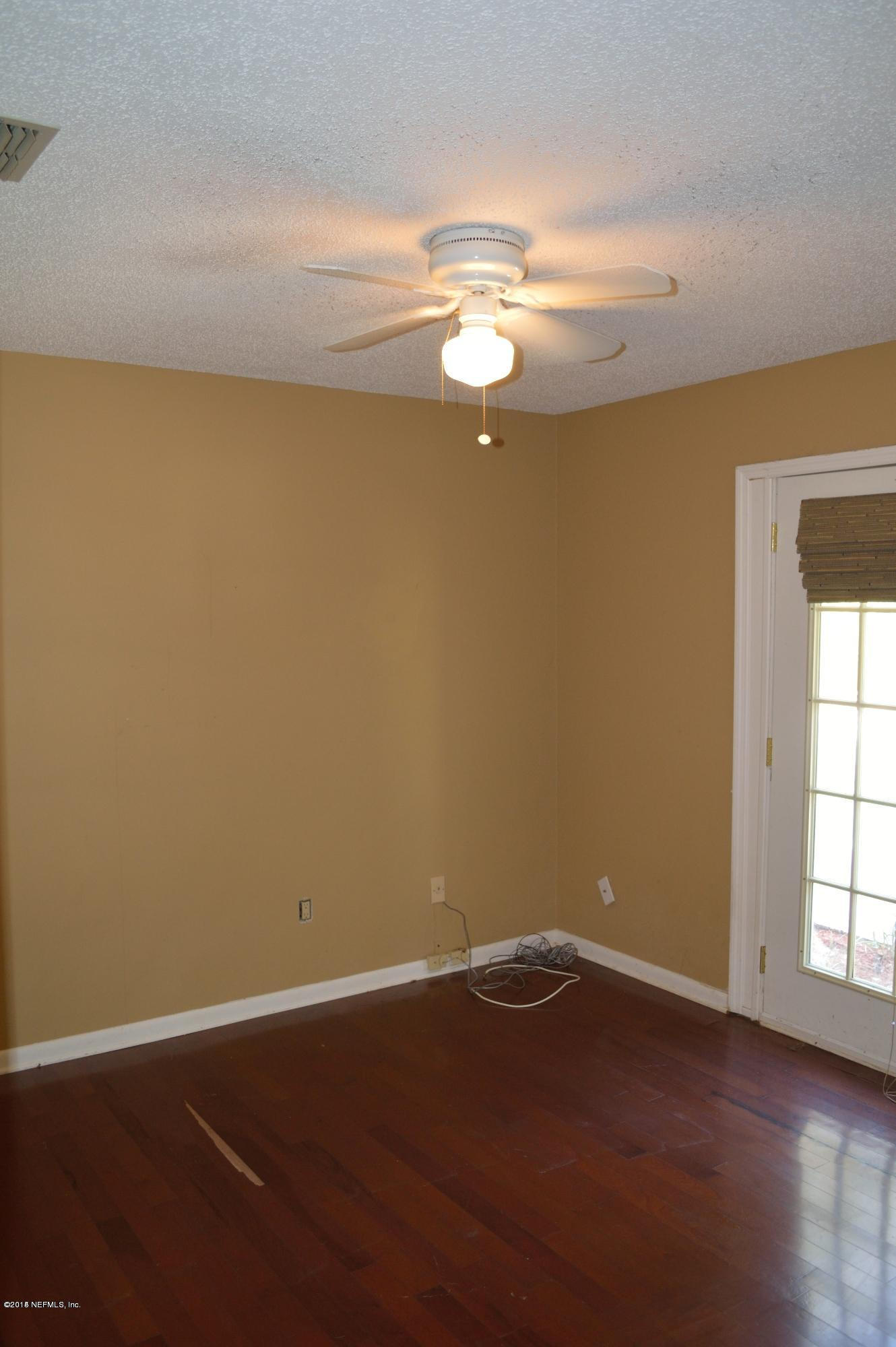 11468 Scott Mill Road Jacksonville, FL 32223 - Photo 12 of 25 an empty room with wooden floor and windows