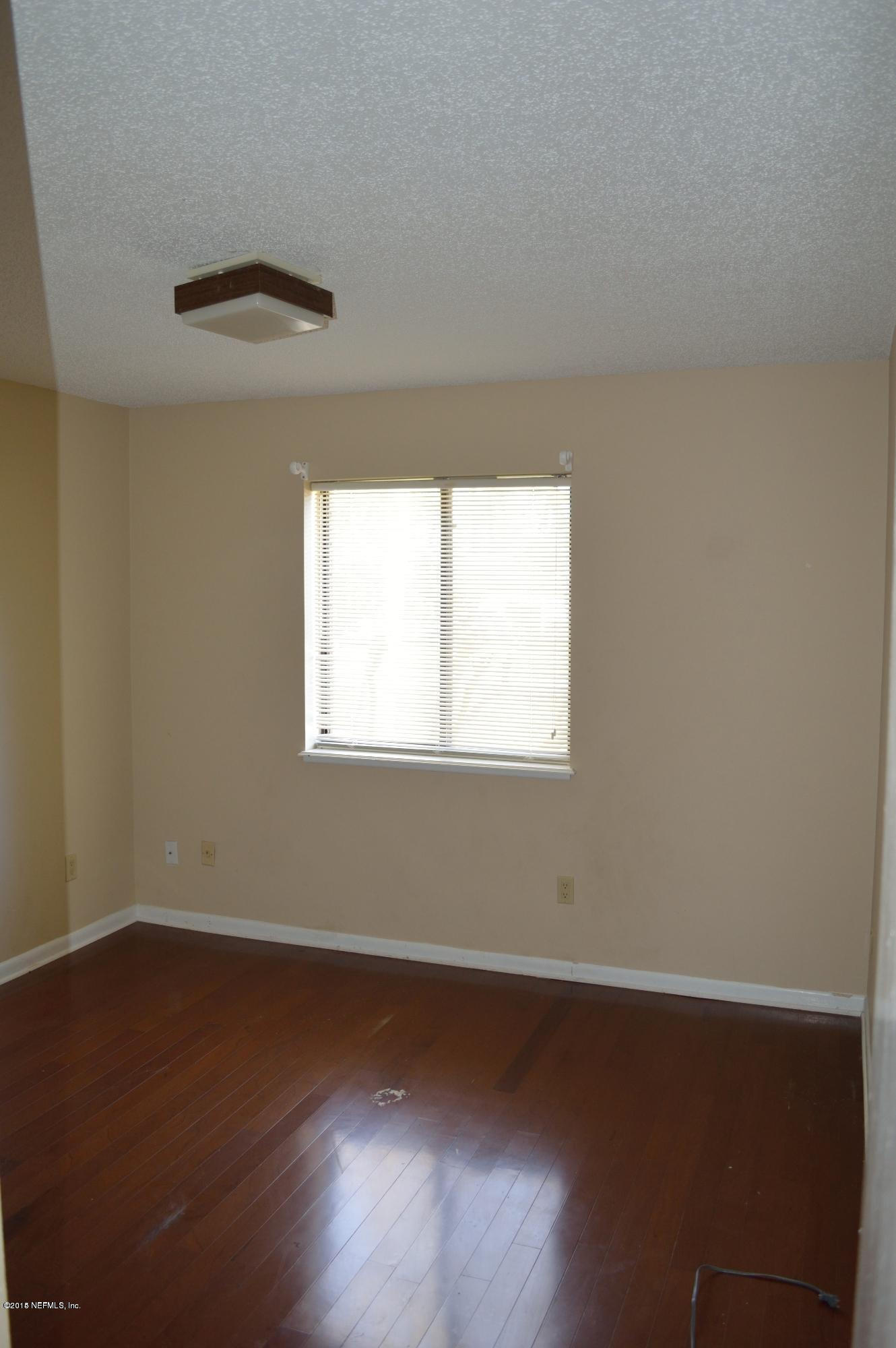 11468 Scott Mill Road Jacksonville, FL 32223 - Photo 13 of 25 an empty room with wooden floor and windows