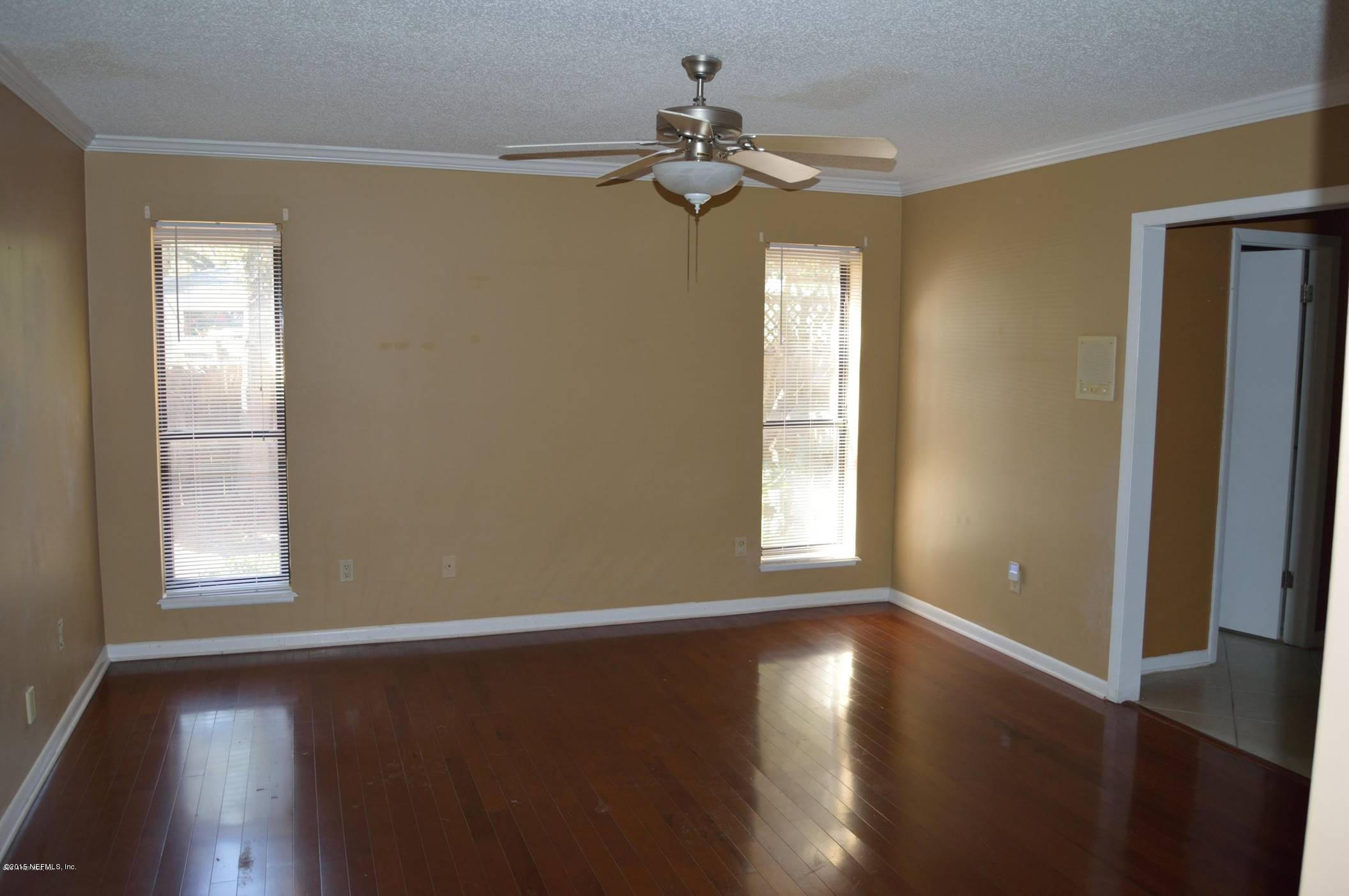 11468 Scott Mill Road Jacksonville, FL 32223 - Photo 17 of 25 a view of empty room with wooden floor and fan