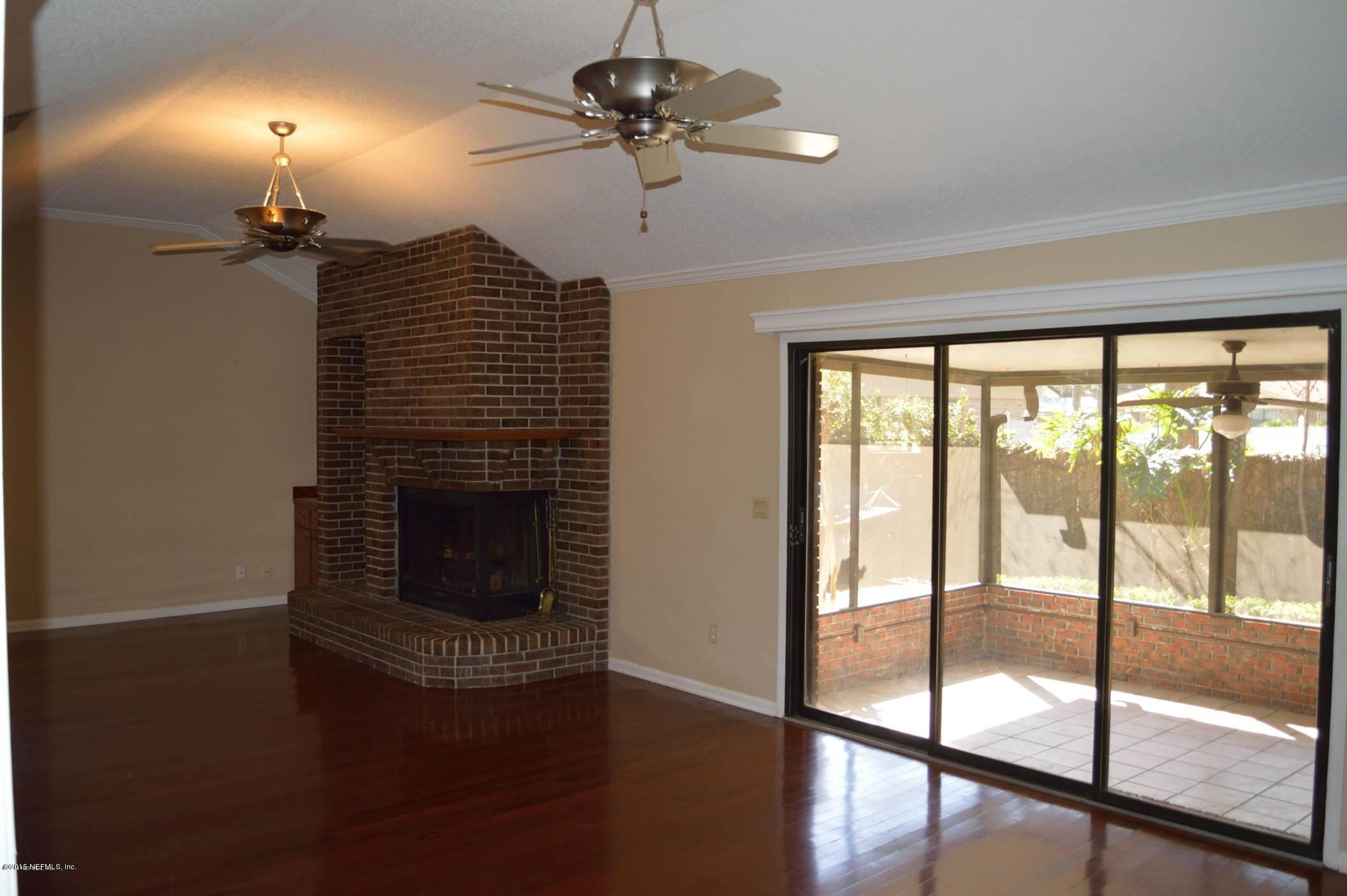 11468 Scott Mill Road Jacksonville, FL 32223 - Photo 8 of 25 a living room with hardwood floor a ceiling fan and a fireplace