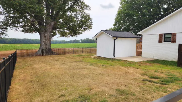 a view of backyard with swimming pool and seating space