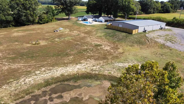 a view of pool with lawn chairs and plants