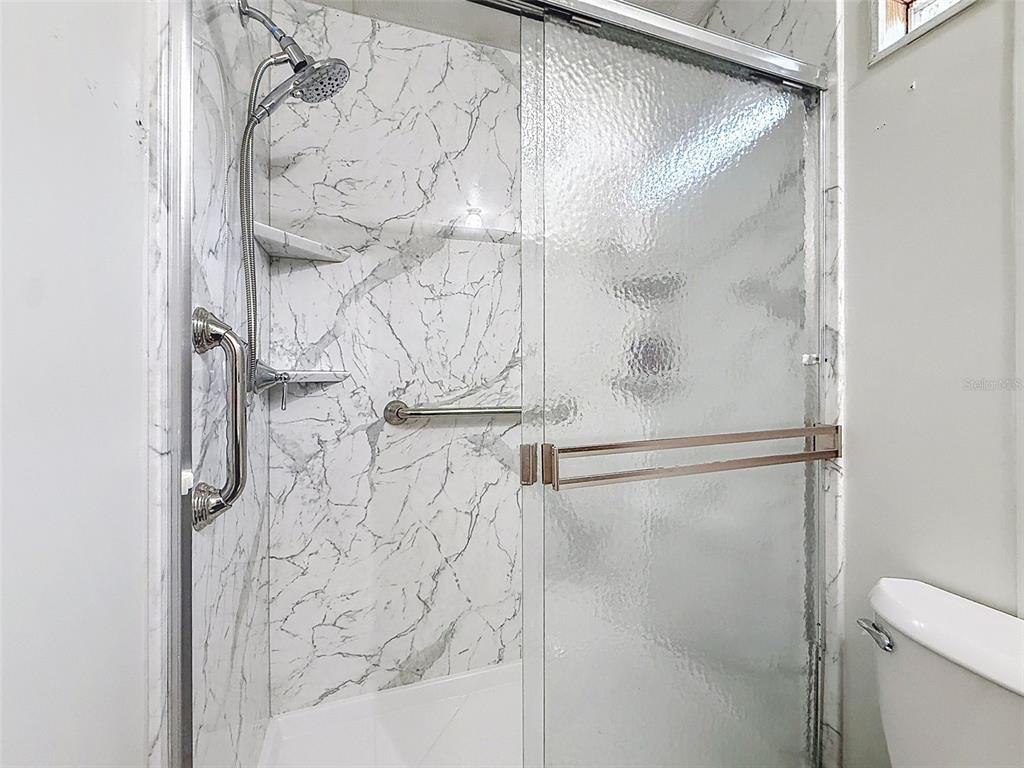 1819 Sinclair Hills Road Lutz, FL 33549 - Photo 43 of 60 a bathroom with a glass shower door