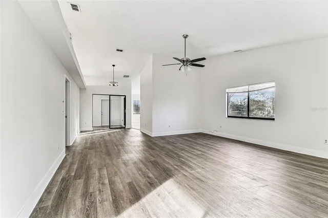 a view of an empty room with cabinet and a window