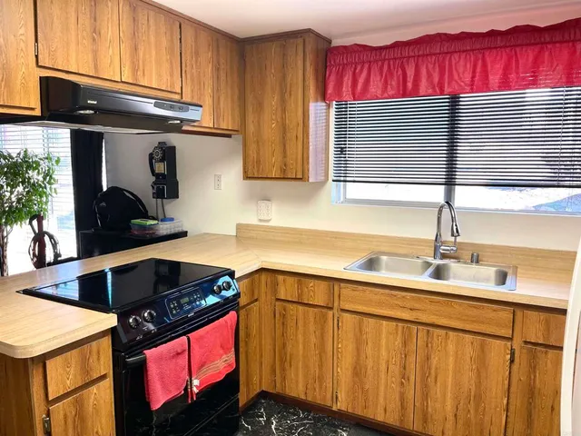 a kitchen with stainless steel appliances granite countertop a sink stove and cabinets