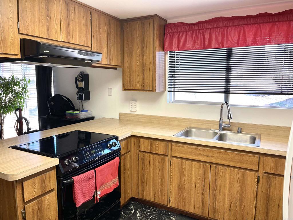 1902 Tierra Del Sol Road Boulevard, CA 91905 - Photo 8 of 37 a kitchen with stainless steel appliances granite countertop a sink stove and cabinets