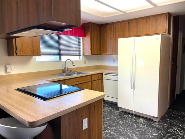 a kitchen with a sink a refrigerator and cabinets