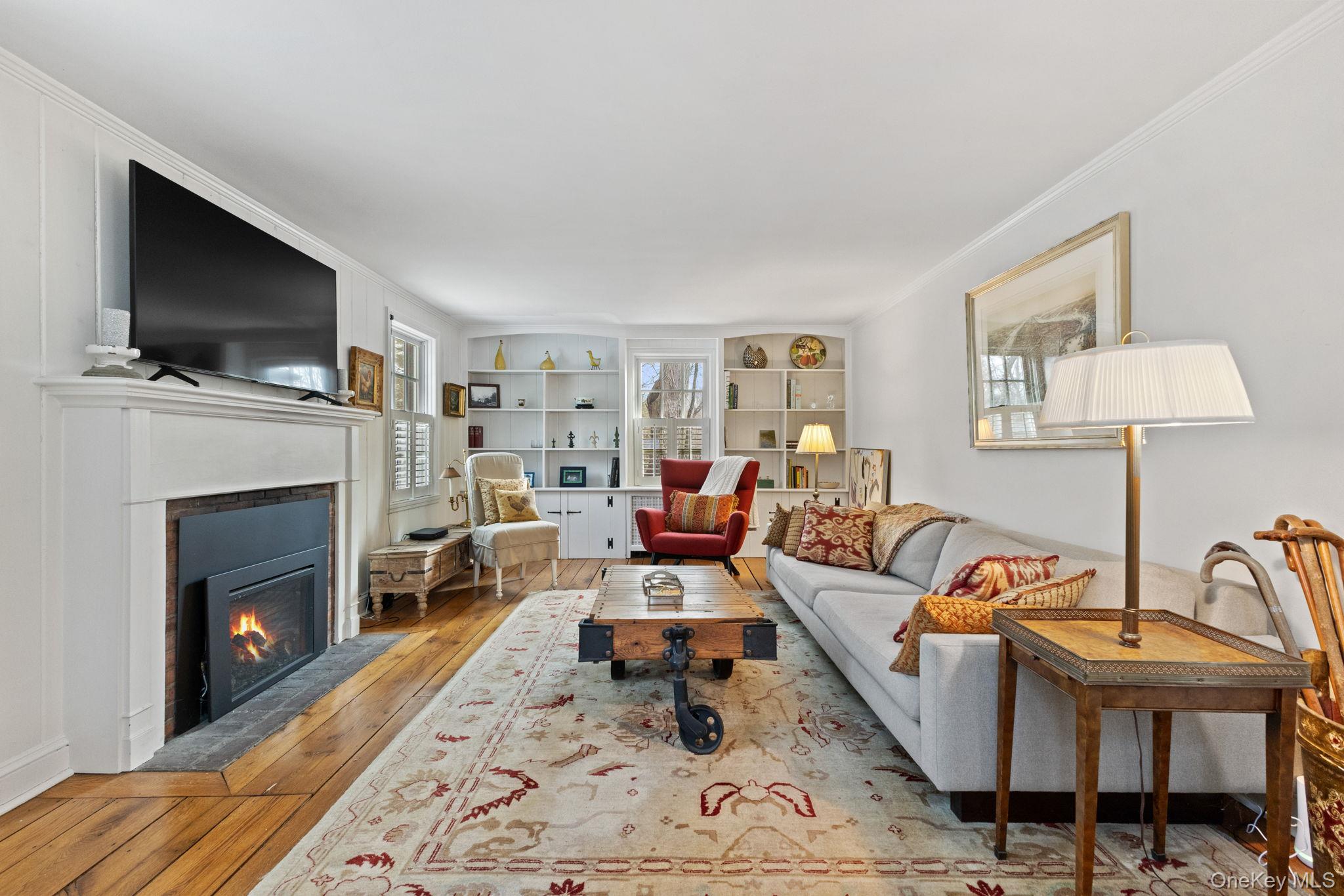 8 South Bedford Road Pound Ridge, NY 10576 - Photo 9 of 32 a living room with furniture a flat screen tv and a fireplace