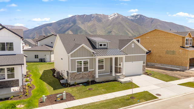 43 South Crimson Way, Unit 311 Mapleton, UT 84664 - Photo 2 of 28 Contemporary single-story residence featuring a gray and stone facade, covered front porch, and an attached two-car garage