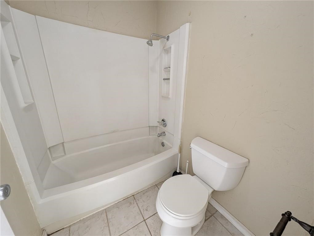 6702 Everhart Road, Unit S104 Corpus Christi, TX 78413 - Photo 15 of 22 a white toilet sitting next to a bath tub