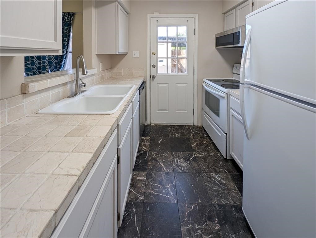 6702 Everhart Road, Unit S104 Corpus Christi, TX 78413 - Photo 9 of 22 a kitchen with a sink stove and cabinets