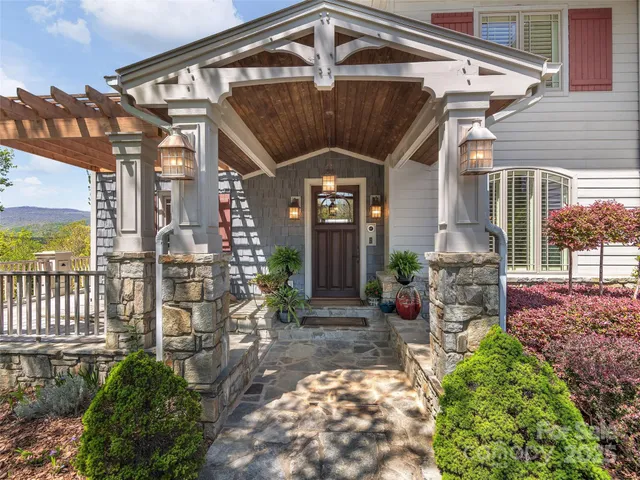 a view of a house with a small yard plants and large tree