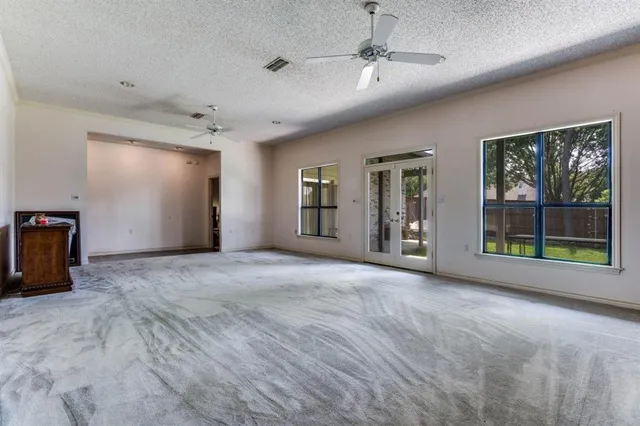 a view of an empty room with a fireplace and a large window
