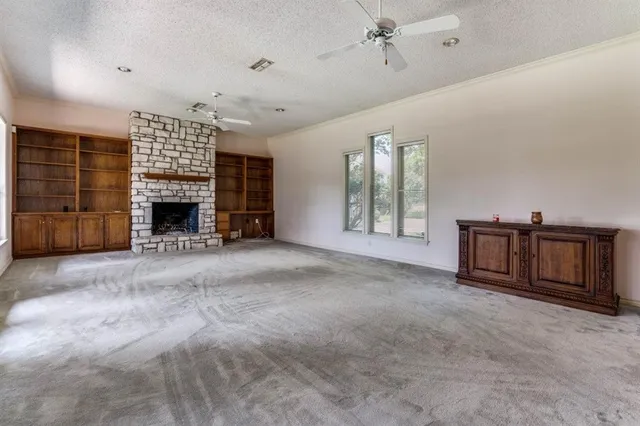 a view of an empty room with a fireplace and a window