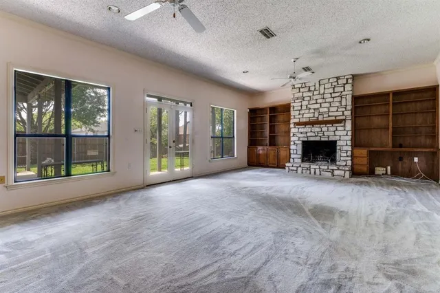 a view of an empty room with a fireplace and a window