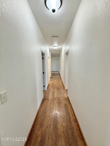 a view of a hallway with wooden floor