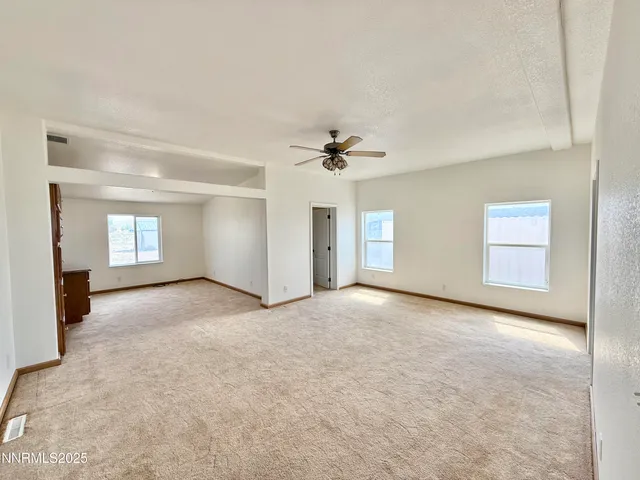 a view of a room with a ceiling fan and window