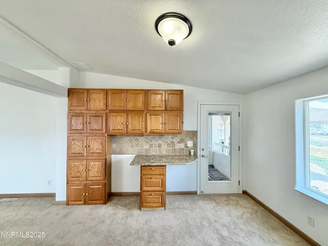 an empty room with fireplace and windows