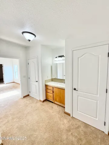 an empty room with a bathroom and mirror