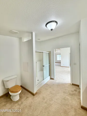 a bathroom with a toilet and a shower