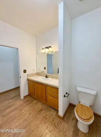 a bathroom with a granite countertop toilet sink and mirror
