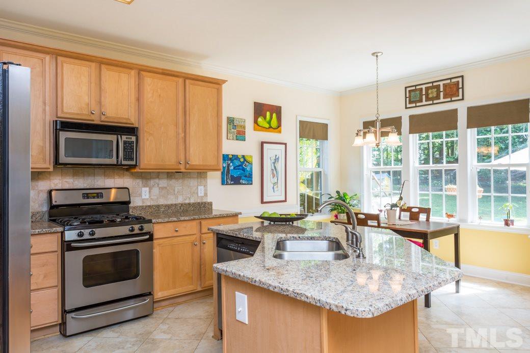 7604 Rambeau Circle Raleigh, NC 27613 - Photo 7 of 25 a kitchen with stainless steel appliances granite countertop a sink stove and microwave