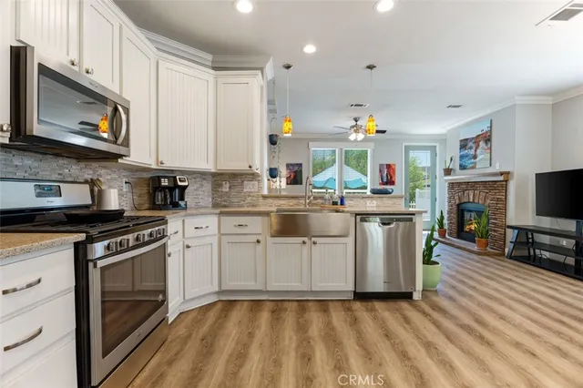a kitchen with white cabinets stainless steel appliances and a sink