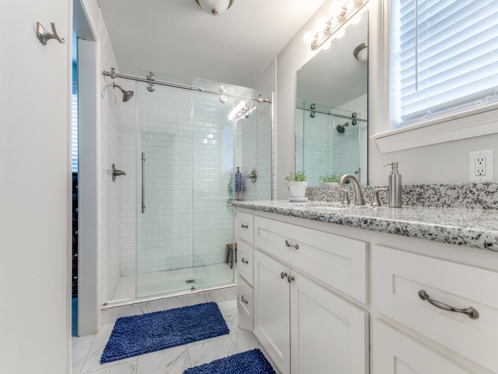 5110 Cochran Street Houston, TX 77009 - Photo 16 of 23 a bathroom with a granite countertop sink a mirror and a shower