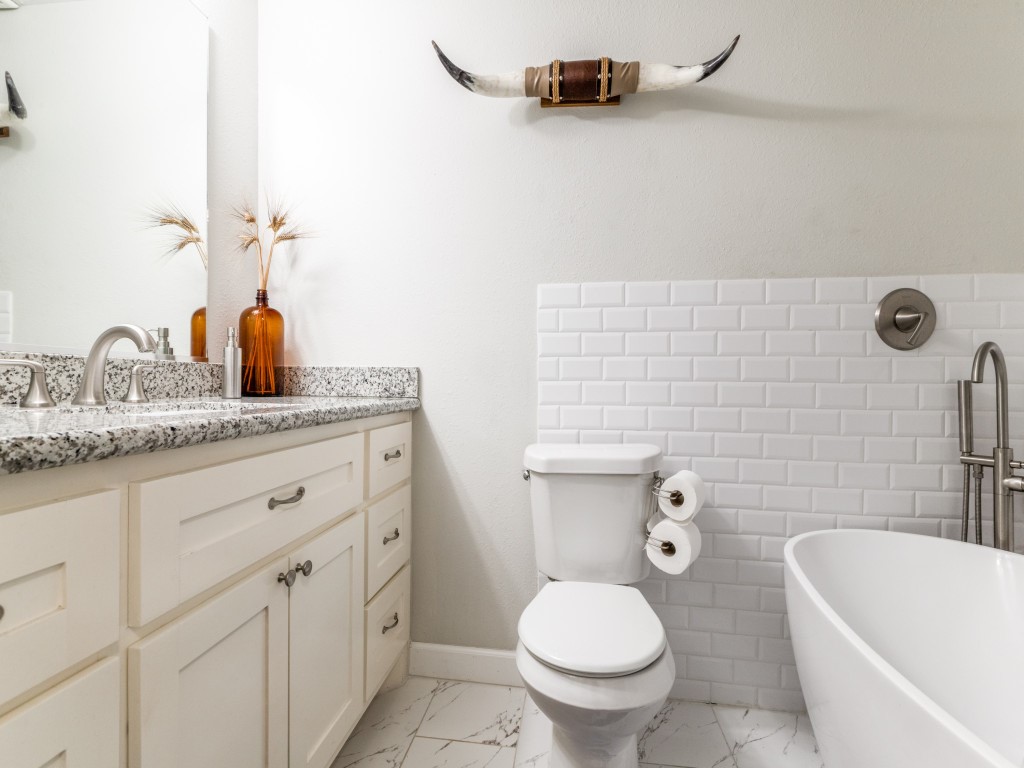 5110 Cochran Street Houston, TX 77009 - Photo 20 of 23 a bathroom with a granite countertop toilet a sink and a bathtub