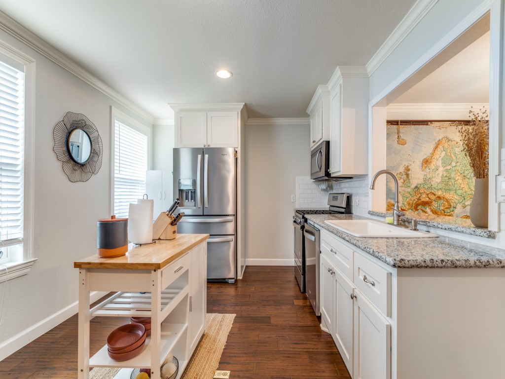 5110 Cochran Street Houston, TX 77009 - Photo 9 of 23 a kitchen with stainless steel appliances granite countertop a stove a sink and a refrigerator