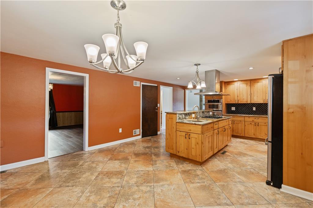 185 Reed Road Avella, PA 15312 - Photo 12 of 50 a large kitchen with a chandelier stainless steel appliances cabinets and a counter top space