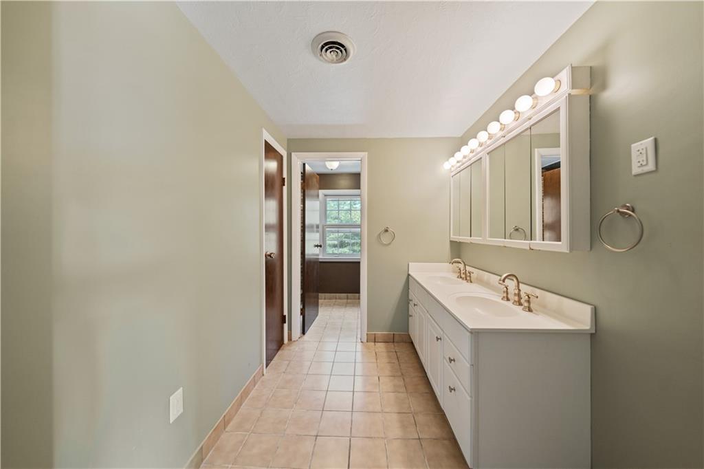 185 Reed Road Avella, PA 15312 - Photo 26 of 50 a bathroom with a double vanity sink and mirror with shower