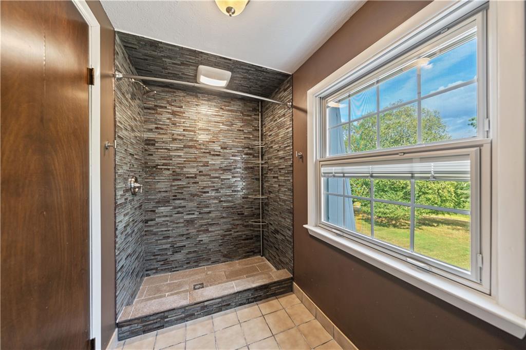 185 Reed Road Avella, PA 15312 - Photo 32 of 50 a bathroom with a glass shower door and a window