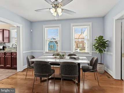a dining room with furniture potted plants and wooden floor