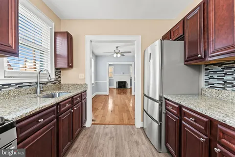a kitchen with stainless steel appliances granite countertop a refrigerator a stove top oven and sink