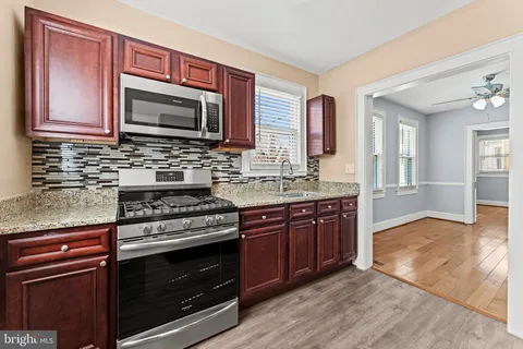 a kitchen with stainless steel appliances granite countertop a stove microwave and sink