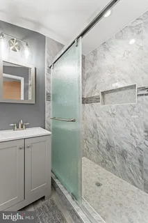a bathroom with a granite countertop sink mirror and shower