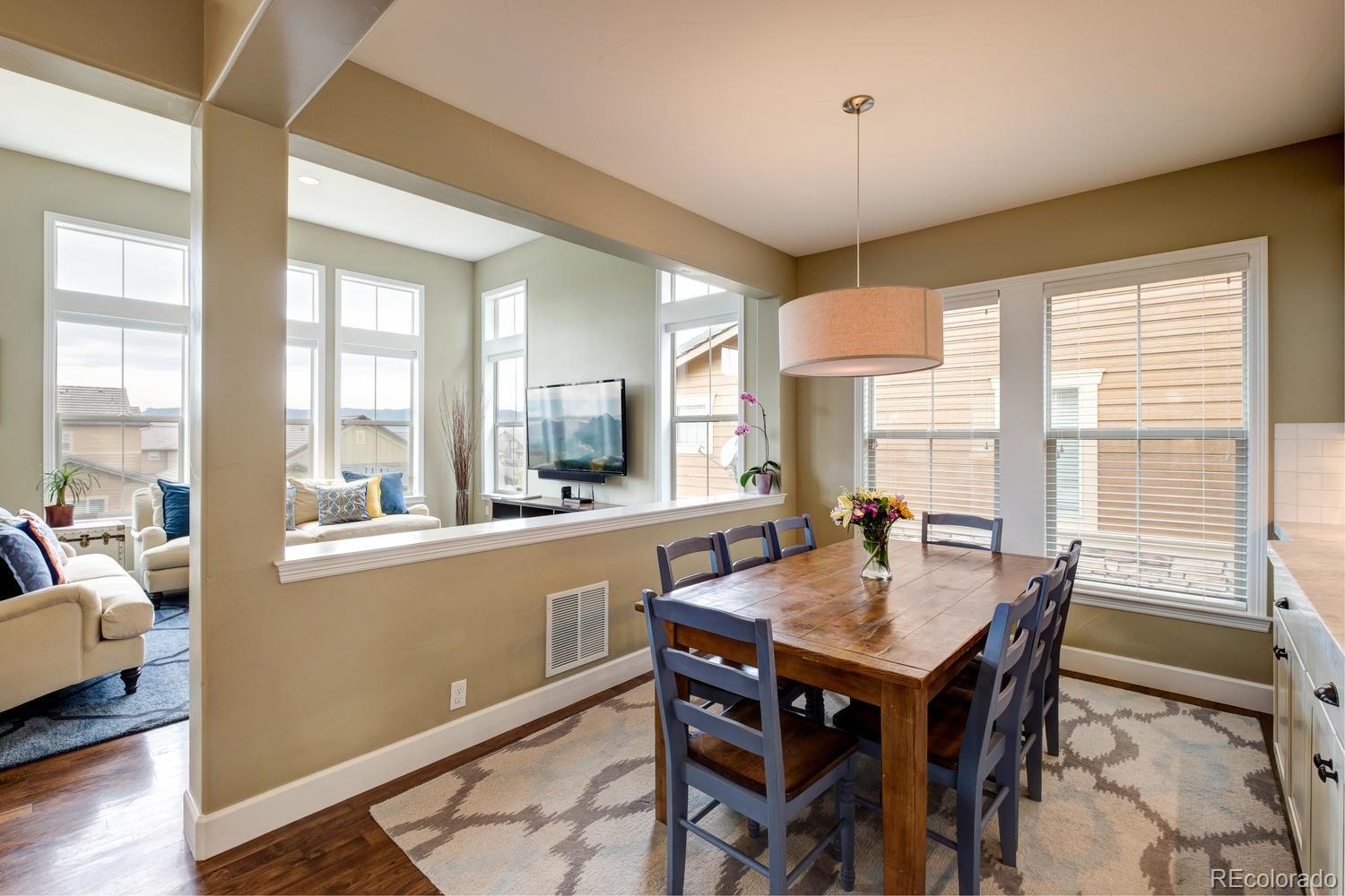 10711 Sundial Rim Road Highlands Ranch, CO 80126 - Photo 14 of 35 a view of a dining room with furniture window and wooden floor