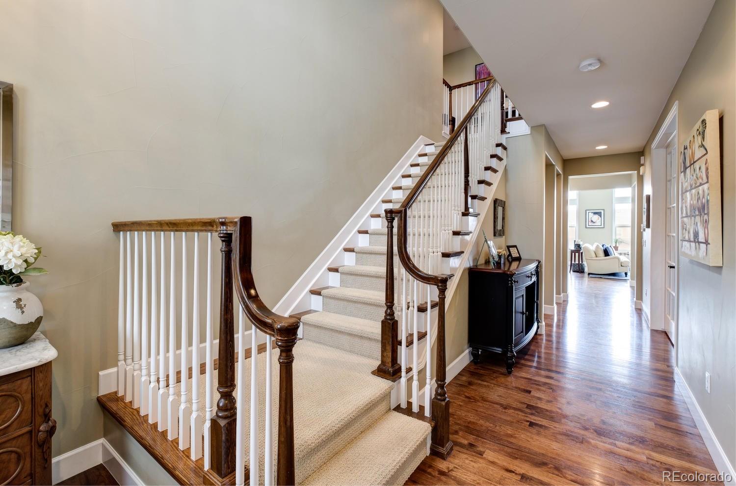 10711 Sundial Rim Road Highlands Ranch, CO 80126 - Photo 28 of 35 a view of a hallway with wooden floor and staircase