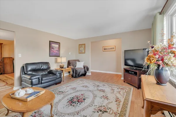 a living room with furniture flat screen tv and a window