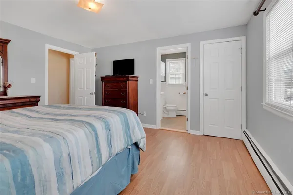 a bedroom with a bed and a flat tv screen on dresser