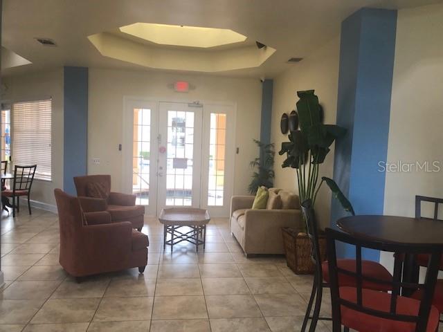 120 Terrace Ridge Circle, Unit 120 Davenport, FL 33896 - Photo 3 of 11 a living room with furniture and floor to ceiling windows
